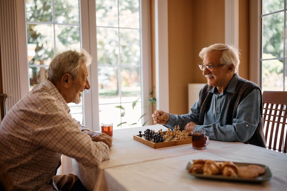 Two men playing chess at home.