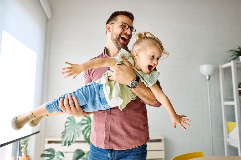 A father playing with his young daughter.