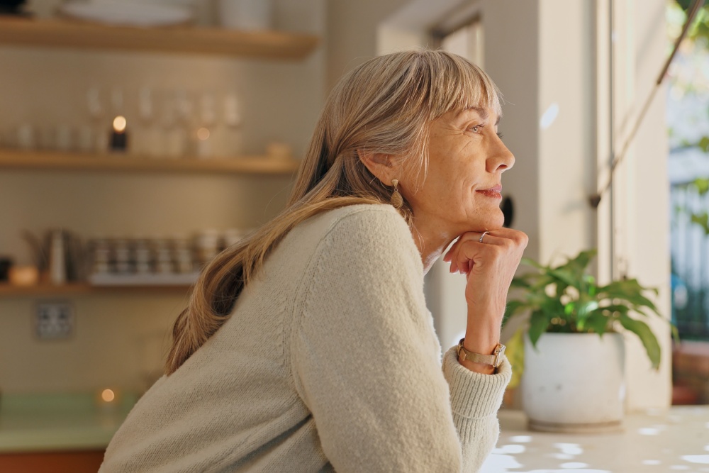 A woman looking out of the window at home.