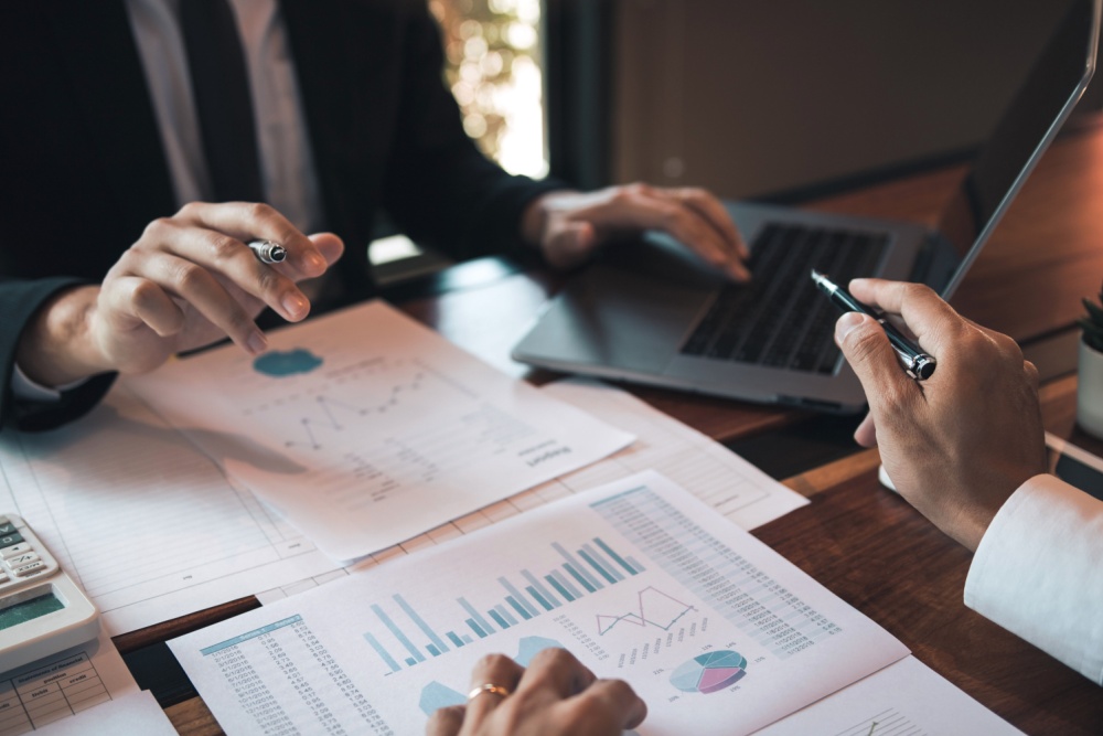 Two people analysing statistical reports.