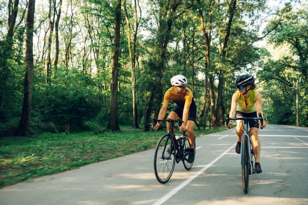 A couple cycling together on a road.